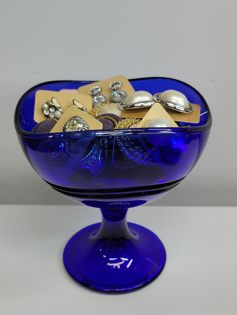 Blue Glass Dish Filled With Earrings